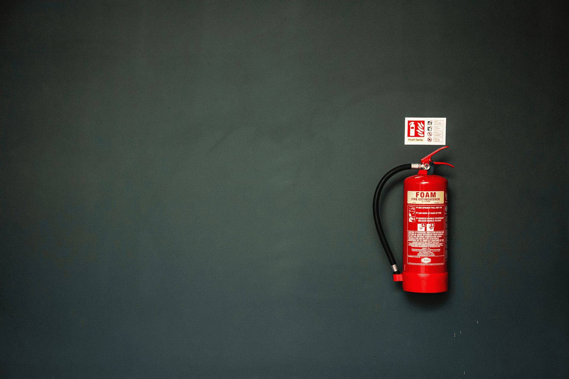 Fire extinguisher on dark grey wall